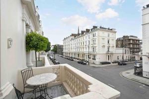 a balcony with a table and chairs and a street at Stunning Grand 2 bed, 2 bath apartment, in London