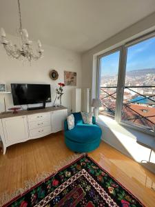 un soggiorno con TV e sedia blu di Lejla apartment a Sarajevo