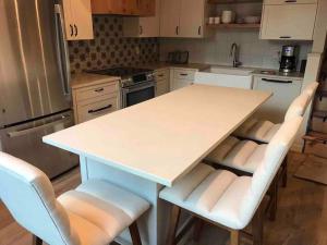 a kitchen with a white table and some chairs at Newly Renovated Creekside Cabin! in Almont