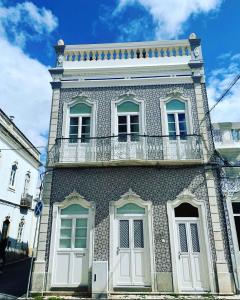 a building with a balcony on the side of it at Casa Cubista in Olhão