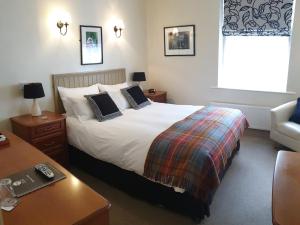 1 dormitorio con cama, escritorio y sofá en The Old Cannon Brewery, en Bury Saint Edmunds