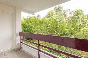 a bench on a balcony with a view of trees at joli appartement avec balcon proximité lac in Annecy