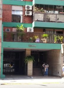 una mujer parada en la puerta de un edificio en Hermoso Departamento para 6 Personas . Excelente ubicacion en Buenos Aires