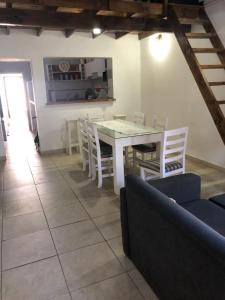 a dining room with a white table and chairs at Casa en Tandil in Tandil