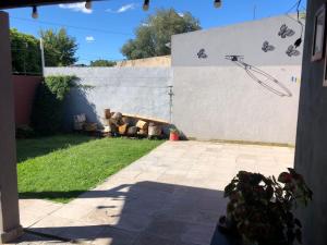 un patio trasero con un sofá contra una pared blanca en Casa en Tandil en Tandil