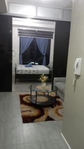 a living room with a table and a bed at Nahas Condo Hotel in Manila