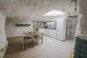 cocina con mesa y sillas en una habitación en PRECIOSA CASA-CUEVA CON JACUZZI, en Paterna