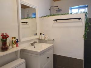 a white bathroom with a sink and a mirror at Contain Jeju-Darangswi in Jeju