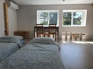 a bedroom with two beds and a table and chairs at Contain Jeju-Darangswi in Jeju