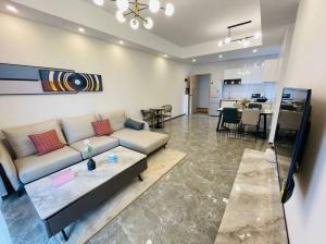 a living room with a couch and a dining room at Embassy Access Golf Apartment in Kigali
