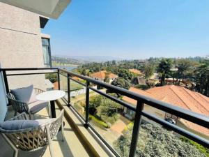 a balcony with a table and chairs and a view at Embassy Access Golf Apartment in Kigali