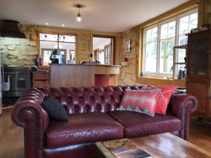 brązowa skórzana kanapa w salonie z kuchnią w obiekcie The Stone Cottage - Bruny Island w mieście Simpsons Bay