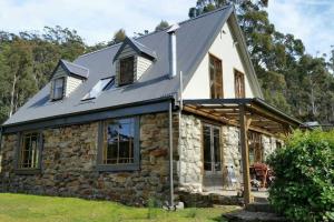 uma casa de pedra com um telhado de metal em The Stone Cottage - Bruny Island em Simpsons Bay