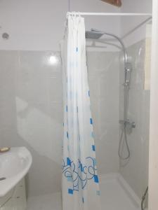 y baño con cortina de ducha y lavamanos. en Rosemary House, en Sarandë