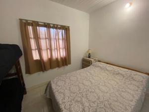a small bedroom with a bed and a window at Casa May - A 15 min del Aeropuerto in Barrio Esteban Echeverría