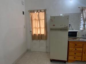 a kitchen with a refrigerator and a door with a window at Casa May - A 15 min del Aeropuerto in Barrio Esteban Echeverría