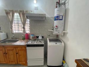 a kitchen with a stove top oven and a dishwasher at Casa May - A 15 min del Aeropuerto in Barrio Esteban Echeverría