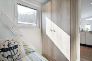 1 dormitorio con cama y ventana en Casa del Sol Scharbeutz - Sauna kostenlos - 1 kleiner Hund willkommen eingezäunter Garten, en Scharbeutz
