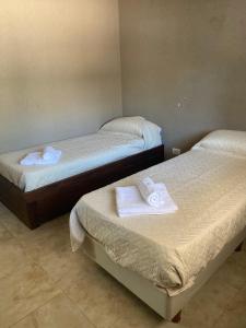 2 camas con toallas en una habitación en Depto Chascomus en Chascomús