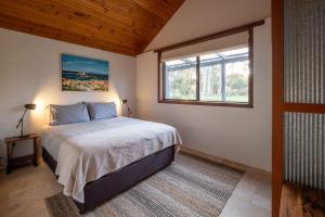 a bedroom with a bed and a window at Burnside Organic Farm in Margaret River Town