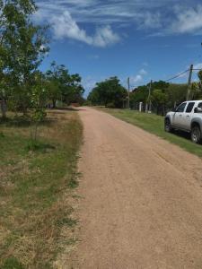 un camino de tierra con un coche blanco estacionado en el lateral en Morgana en Cuchilla Alta