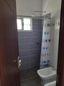 uma casa de banho com um WC, um lavatório e um chuveiro em Morgana em Cuchilla Alta