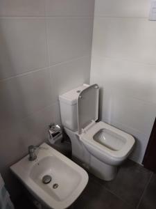 uma casa de banho com um WC branco e um lavatório. em Morgana em Cuchilla Alta