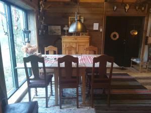 jadalnia z drewnianym stołem i krzesłami w obiekcie Stenlängan Lodge w mieście Lönsboda