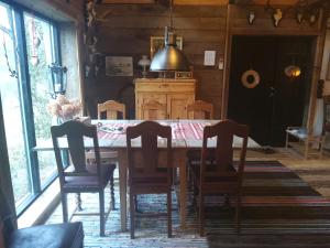 a dining room with a wooden table and chairs at Stenlängan Lodge in Lönsboda