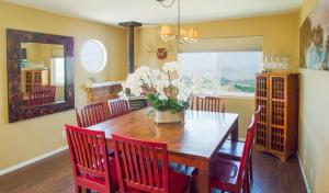 a dining room with a wooden table and red chairs at Mountain Top - Best View in SLO in San Luis Obispo