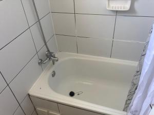 a white bath tub in a white tiled bathroom at Altavistamar in Viña del Mar