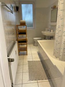 ein Badezimmer mit einer Badewanne, einem Waschbecken und einem WC in der Unterkunft Appartement La Vie en Rose in Essen