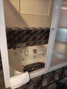 a bath tub in a bathroom with a glass door at Azores House in Ponta Delgada