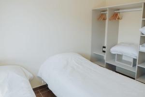 1 dormitorio con cama blanca y espejo en LAS LOICAS en Esquel