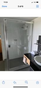 y baño con ducha acristalada y lavamanos. en Resort One Bedroom Apartment, en Pelican Waters