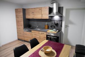 a kitchen with a wooden table and a kitchen with a sink at RIMA Apart‘s in Heiterwang