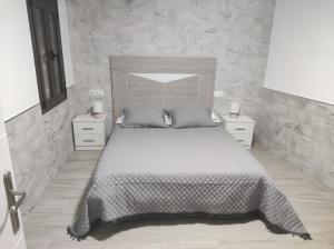 a bedroom with a large bed and two night stands at Apartamento Daniela 1 in Ronda