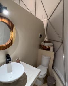 a bathroom with a white sink and a toilet at Glamping Mayan Glam in Tulum