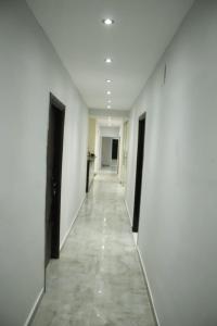un lungo corridoio con pareti bianche e pavimento piastrellato di METROPOLITANO a Il Cairo