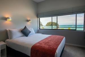 a bedroom with a bed and a large window at Kaiteriteri Reserve Apartments in Kaiteriteri