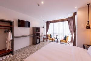 um quarto de hotel com uma cama grande e uma sala de estar em Siem Reap Palace Hotel & Spa em Siem Reap