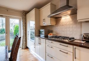 a kitchen with white cabinets and a stove top oven at Kenmare Townhouse in Kenmare