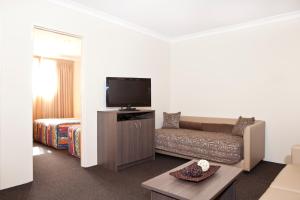 a living room with a couch and a flat screen tv at Narellan Motor Inn in Narellan