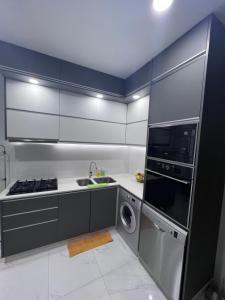 una cocina con electrodomésticos de acero inoxidable, lavadora y secadora en Résidence majorel en Kenitra