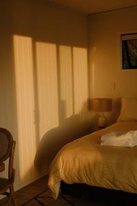Schlafzimmer mit einem Bett und einem Fenster mit Jalousien in der Unterkunft Tatapouri Bay in Gisborne