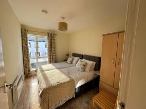 a bedroom with a bed and a large window at Town Centre Apartment in Westport