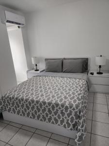 a white bedroom with a bed and two night stands at San Juan Apartments in San Juan