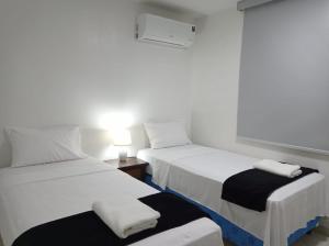 two beds in a hotel room with towels on them at Doña Nancy in Panama City