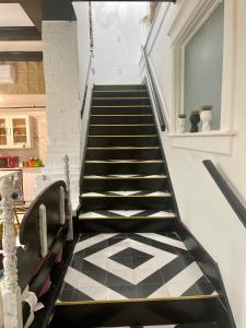 a staircase with a black and white tiled floor at Prestige Collection, Hotel Boutique in St. Petersburg