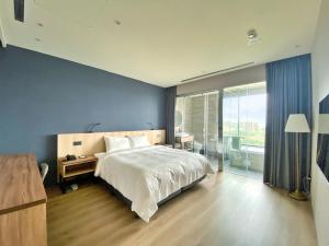 a bedroom with a large bed and a large window at alfar Hotel in Dayuan